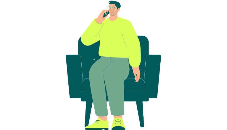 Ein Mann der auf einem Sofasessel sitzt und telefoniert.